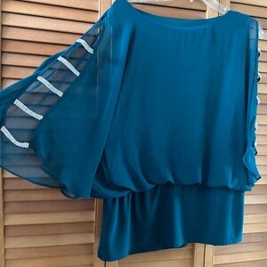 This is a beautiful, sheer dark teal blouse. It’s perfect for evening wear.